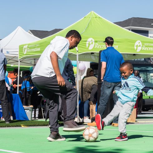 adult and child playing soccer