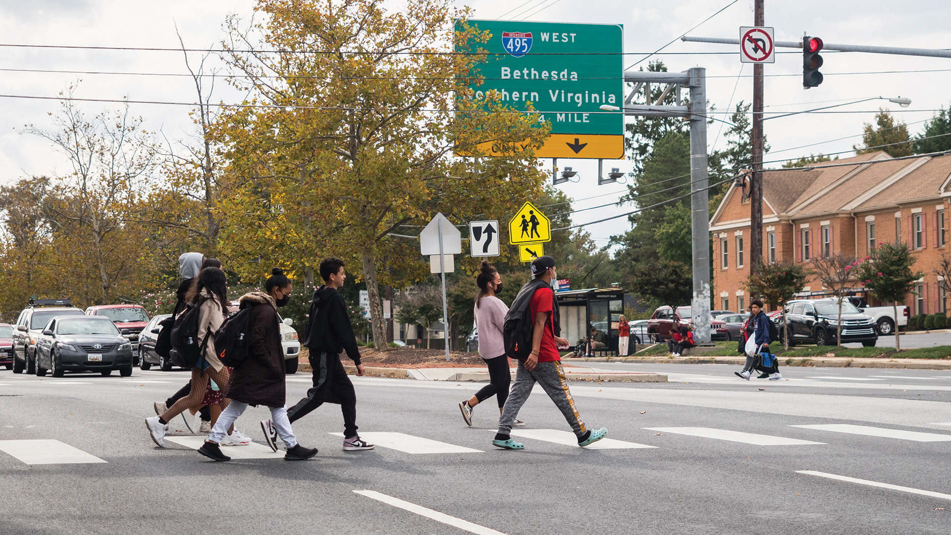 group of people crossing a busy road in a crosswalk